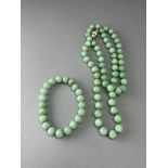 A Jadeite bead Necklace, and a Bangle en suite the small round beads of soft fairly even pale