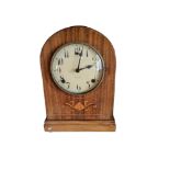 AN EDWARDIAN MAHOGANY MANTLE CLOCK Having a dime form case with floral inlaid panel, dial marked '