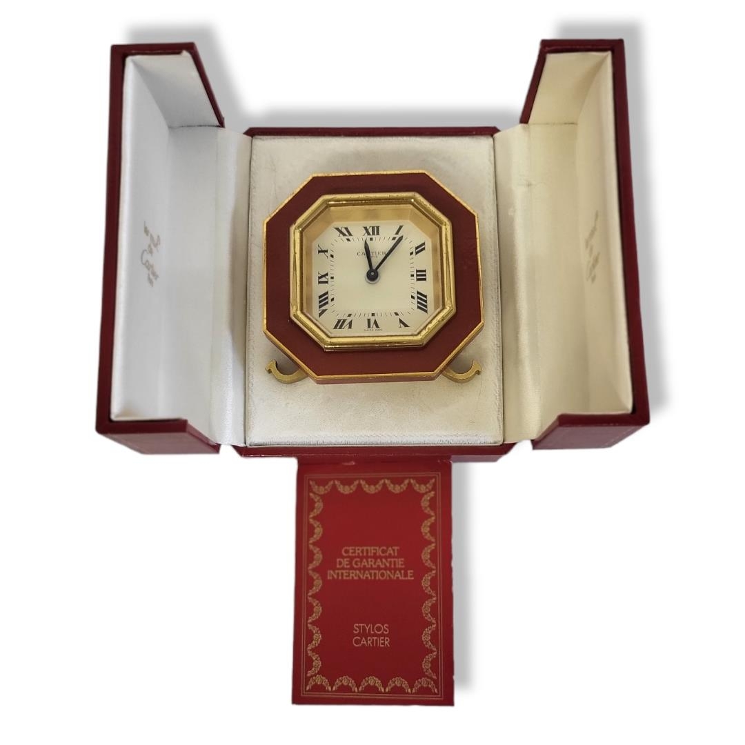CARTIER, MUST DE CARTIER, A VINTAGE GILT METAL AND ENAMEL TRAVEL CLOCK Octagonal form with red - Image 11 of 14
