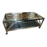 A STAINLESS STEEL COFFEE TABLE With plate glass top above a sectional black leather undertier,