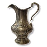 A VICTORIAN SILVER CREAM JUG Having a single handle and embossed decoration, hallmarked E.E. and J.