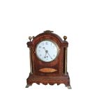 AN EDWARDIAN MAHOGANY AND BRASS MANTLE CLOCK Having a single carry handle, spherical finials ,column