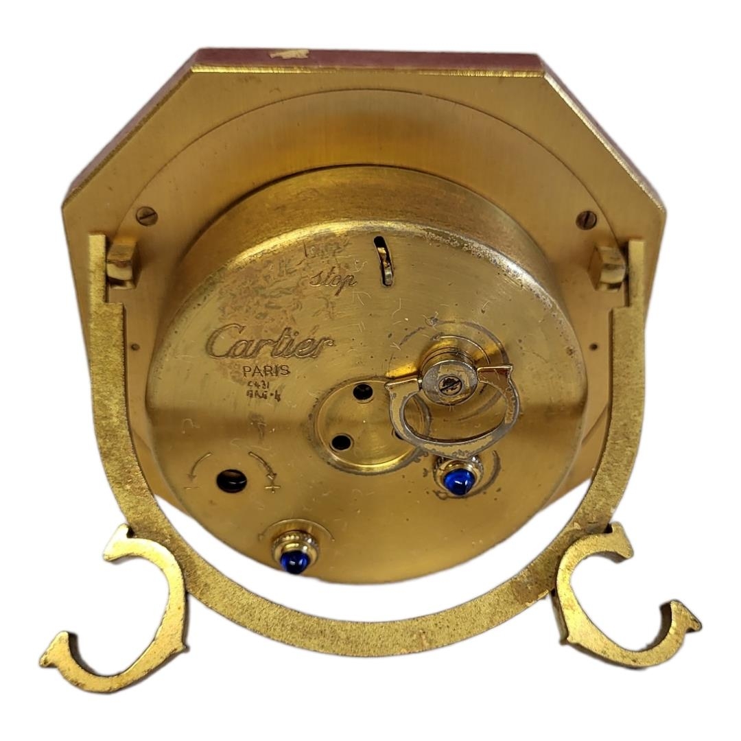 CARTIER, MUST DE CARTIER, A VINTAGE GILT METAL AND ENAMEL TRAVEL CLOCK Octagonal form with red - Image 9 of 14