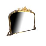 A LARGE VICTORIAN GILT FRAMED OVER MANTLE MIRROR With scolding foliage crest above original arched