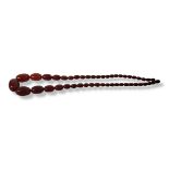 A VICTORIAN CHERRY AMBER NECKLACE Having a graduated row of oval beads. (approx 60cm) Condition: