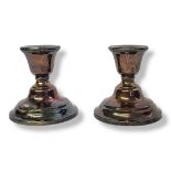 A PAIR OF EARLY 20TH CENTURY SILVER SQUAT FORM CANDLESTICKS On circular bases, hallmarked