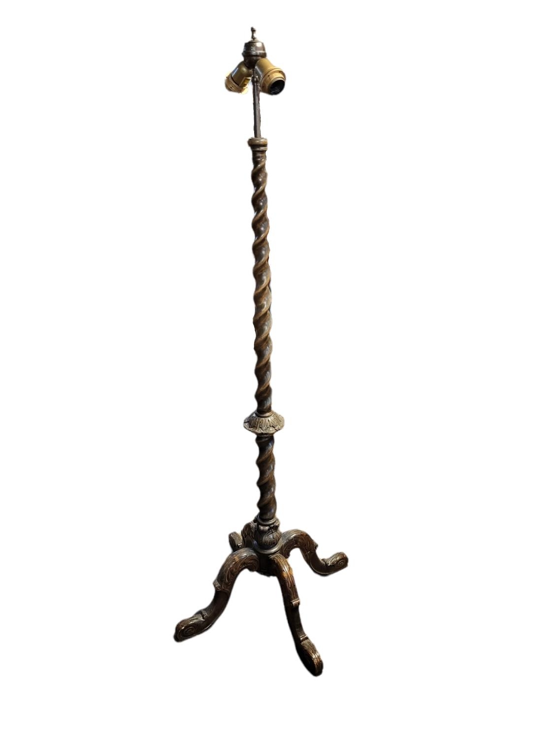 AN EARLY 20TH CENTURY BEECHWOOD STANDARD LAMP Supported on a barley twist column on three acanthus