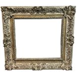 A 19TH CENTURY PARCEL GILT AND PAINTED GESSO FRAME Decorated with shells and scrolling foliage. (