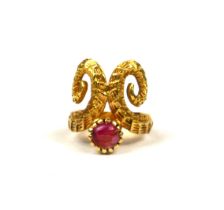 AN 18CT YELLOW GOLD AND RUBY RING HAVING STYLISED RAMS HORN DESIGN. (UK ring size K, gross weight
