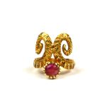 AN 18CT YELLOW GOLD AND RUBY RING HAVING STYLISED RAMS HORN DESIGN. (UK ring size K, gross weight