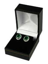 A PAIR 18CT WHITE GOLD OVAL EMERALD AND DIAMOND CLUSTER STUDS with WGI Certificate. (Emeralds 3.