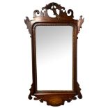A 19TH CENTURY MAHOGANY, PARCEL GILT AND SHELL INLAID FRAMED MIRROR The central crest carved with