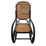 A 20TH CENTURY BENTWOOD ROCKING CHAIR With cane back and seat and scrolling arms.