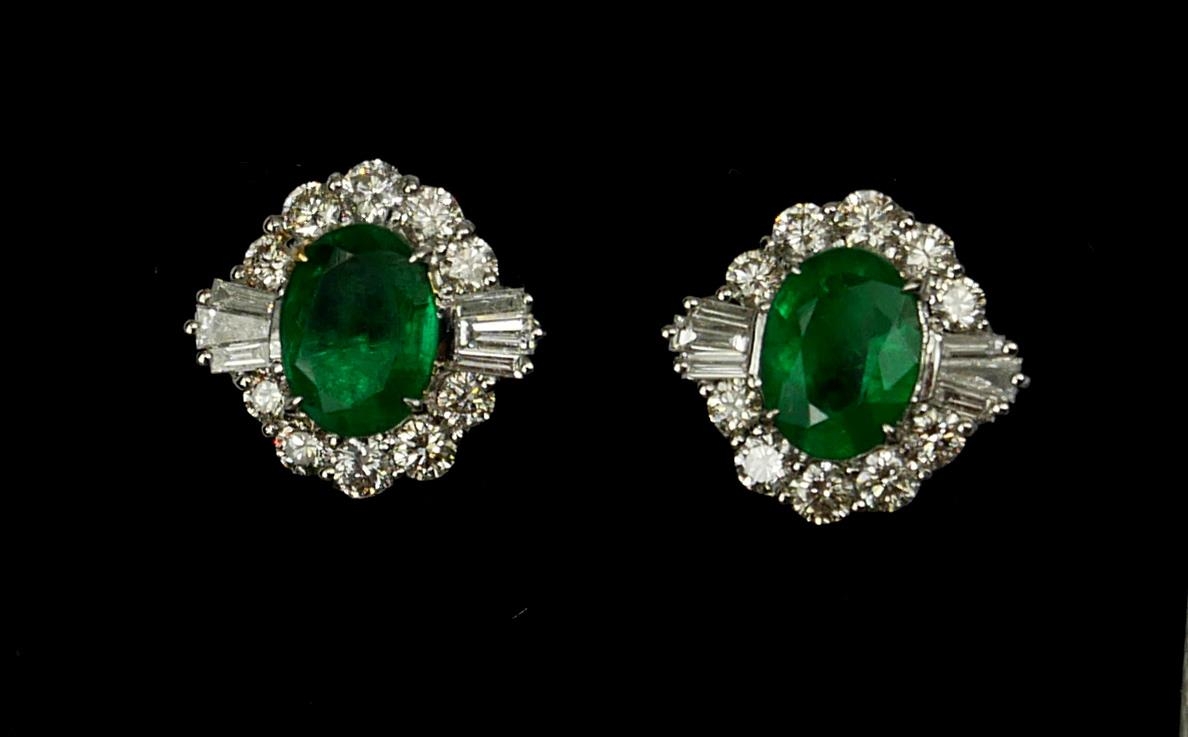 A PAIR OF 18CT WHITE GOLD OVAL EMERALD AND DIAMOND CLUSTER STUD EARRINGS. (Approx Emeralds 2.05ct. - Image 2 of 2