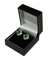 A PAIR OF 18CT WHITE GOLD OVAL EMERALD AND DIAMOND CLUSTER STUD EARRINGS. (Approx Emeralds 2.05ct.