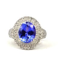 AN 18CT WHITE GOLD LARGE OVAL TANZANITE & DIAMOND RING, The tanzanite surrounded by a double halo of
