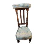 A LATE 20TH CENTURY OAK PRAYER CHAIR Having upholstered head rail and carved column supports. (