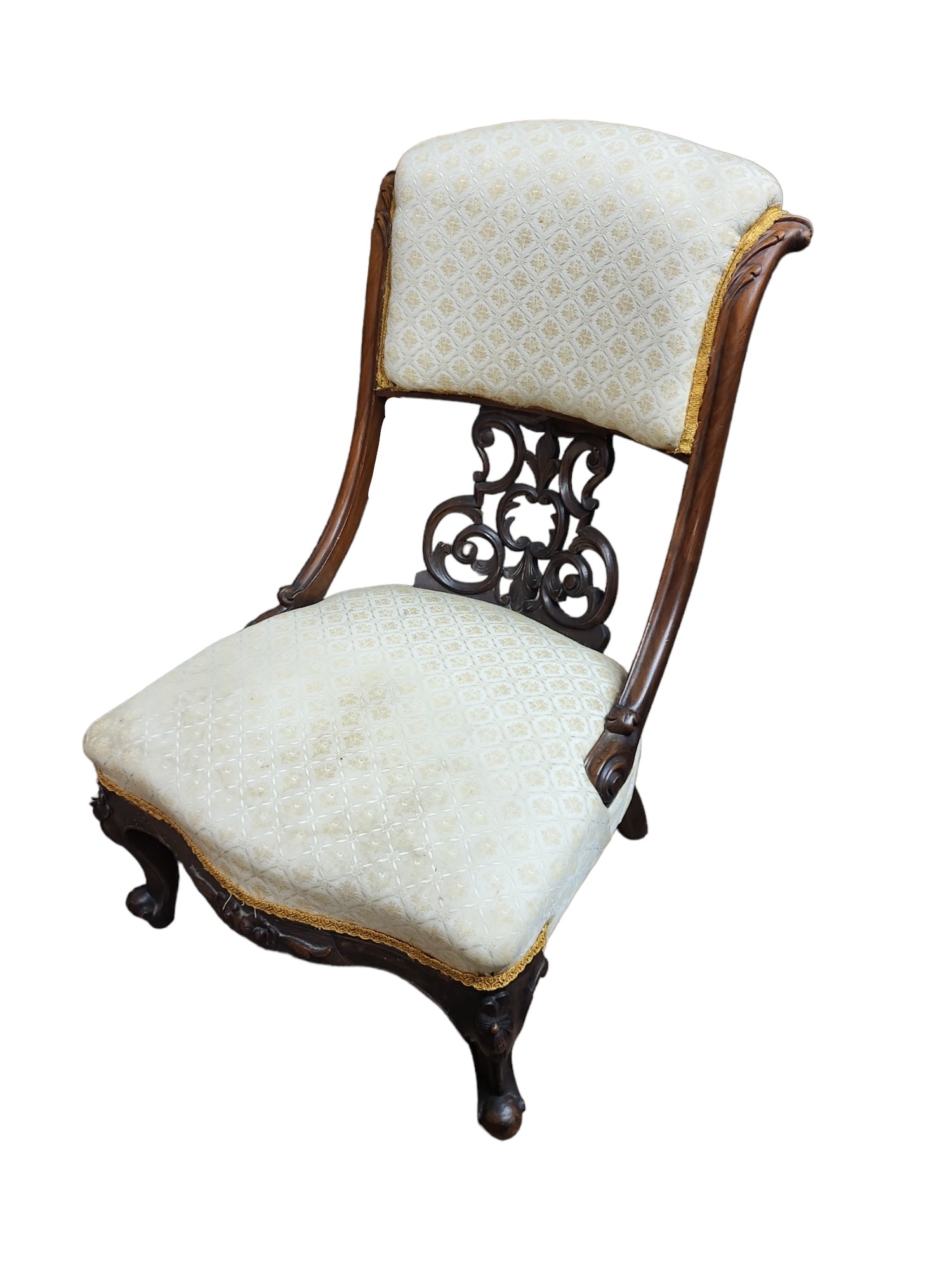 A VICTORIAN MAHOGANY NURSING CHAIR With scroll back, fretwork panelled, fabric upholstery, on