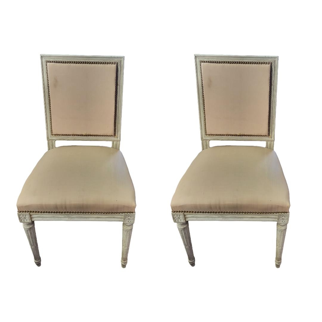 A PAIR OF LATE 19TH CENTURY FRENCH SALON CHAIRS In a distressed cream painted finish and upholstered