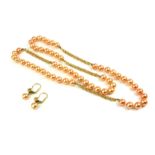 A VINTAGE CONTINENTAL YELLOW METAL AND CULTURED PEARL NECKLACE A row of champagne tone pearls