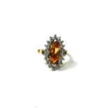 AN 18CT YELLOW AND WHITE GOLD, CITRINE AND DIAMOND CLUSTER RING Having central marquise cut