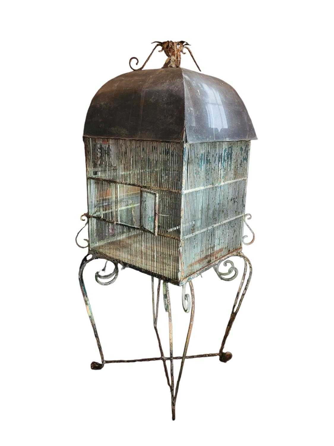 A LARGE 19TH CENTURY PAINTED IRON AND ZINC DOMED TOPPED BIRDCAGE ON WROUGHT IRON SCROLL WORK