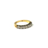 AN 18CT GOLD AND DIAMOND RING Set with seven round cut diamonds flanked by indented finish
