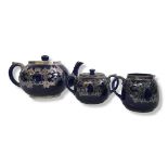 AN EARLY 20TH CENTURY POTTERY AND SILVER OVERLAID THREE PIECE TEA SET Comprising a teapot, sugar