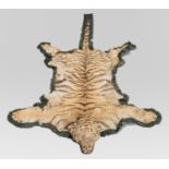 AN EARLY 20TH CENTURY TAXIDERMY TIGER SKIN RUG. (l 265cm x w 165cm)