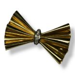 A VINTAGE 18CT GOLD AND DIAMOND BOW BROOCH The row of round cut diamonds in a geometric form. (
