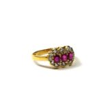 AN 18CT GOLD, RUBY AND DIAMOND RING Having three oval cut rubies surrounded by a halo of round cut