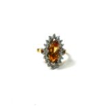 AN 18CT YELLOW AND WHITE GOLD, CITRINE AND DIAMOND CLUSTER RING Having central marquise cut