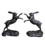 A PAIR OF CAST BRONZE BOXING HARES Supported on marble bases. (h 29.5cm x w 21.5cm x depth 12cm)