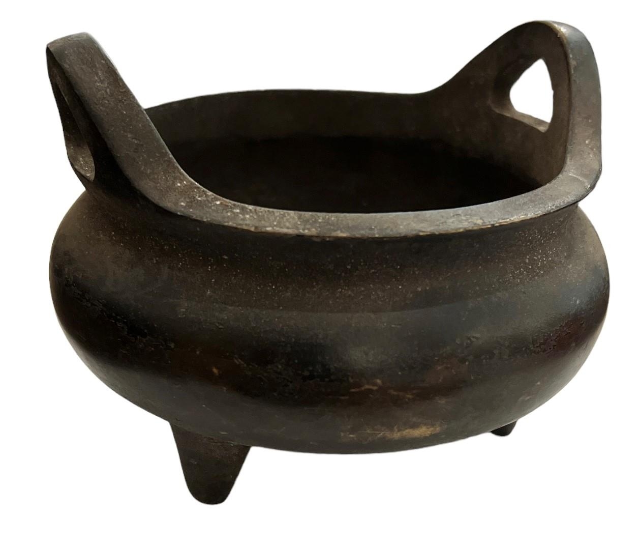 A SMALL TWIN HANDLED CHINESE BRONZE INCENSE BURNER Marked to base. (h 9cm x diameter 13cm)