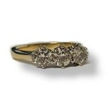 AN 18CT GOLD AND DIAMOND THREE STONE RING The row of round cut diamonds on a plain gold shank. (