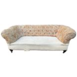 A 19TH CENTURY VICTORIAN BUTTON BACK CHESTERFIELD SOFA Raised on turned legs terminating on brass