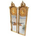 A PAIR OF GILT ROCOCO DESIGN PIER MIRRORS With central oval bust portraits and scrolling foliage