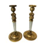 A PAIR OF GILT BRONZE AND ROCK CRYSTAL CANDLESTICKS Having mural face stems. (h 29cm x diameter 12.