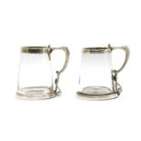 A pair of Victorian silver mounted glass mugs,