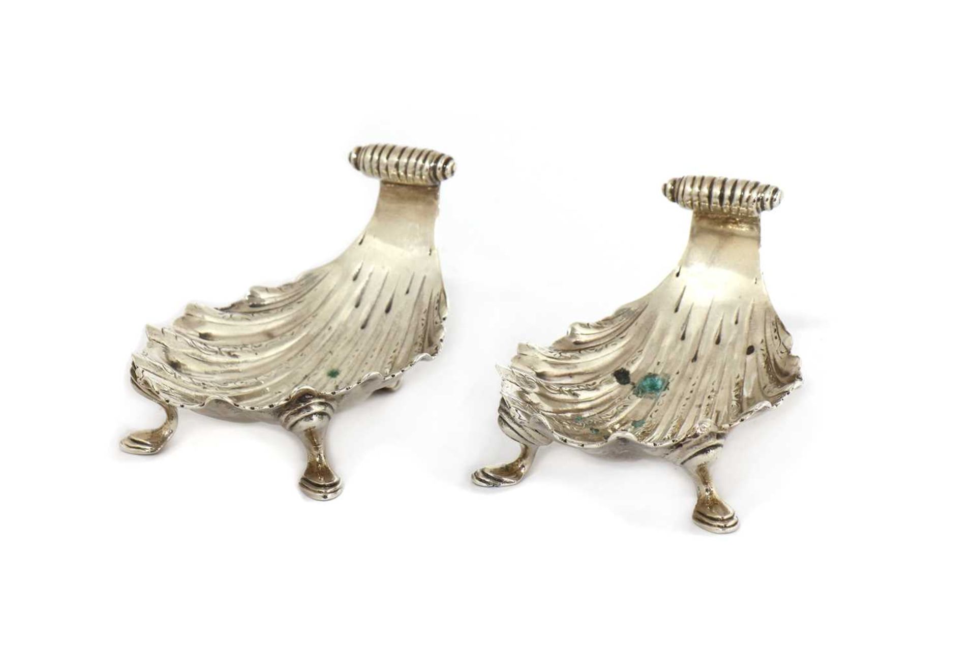 A pair of cast white metal shell butter dishes,