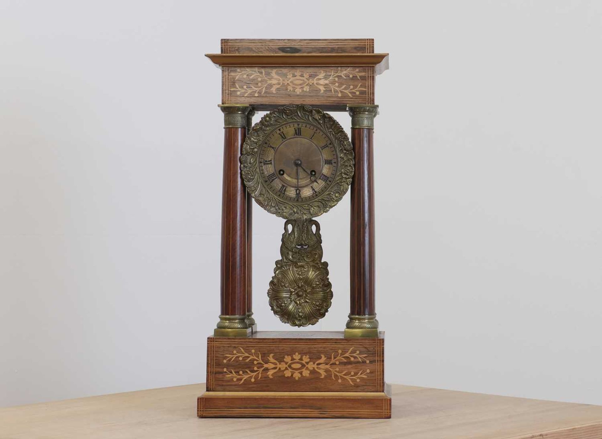 A rosewood and brass inlaid portico clock,
