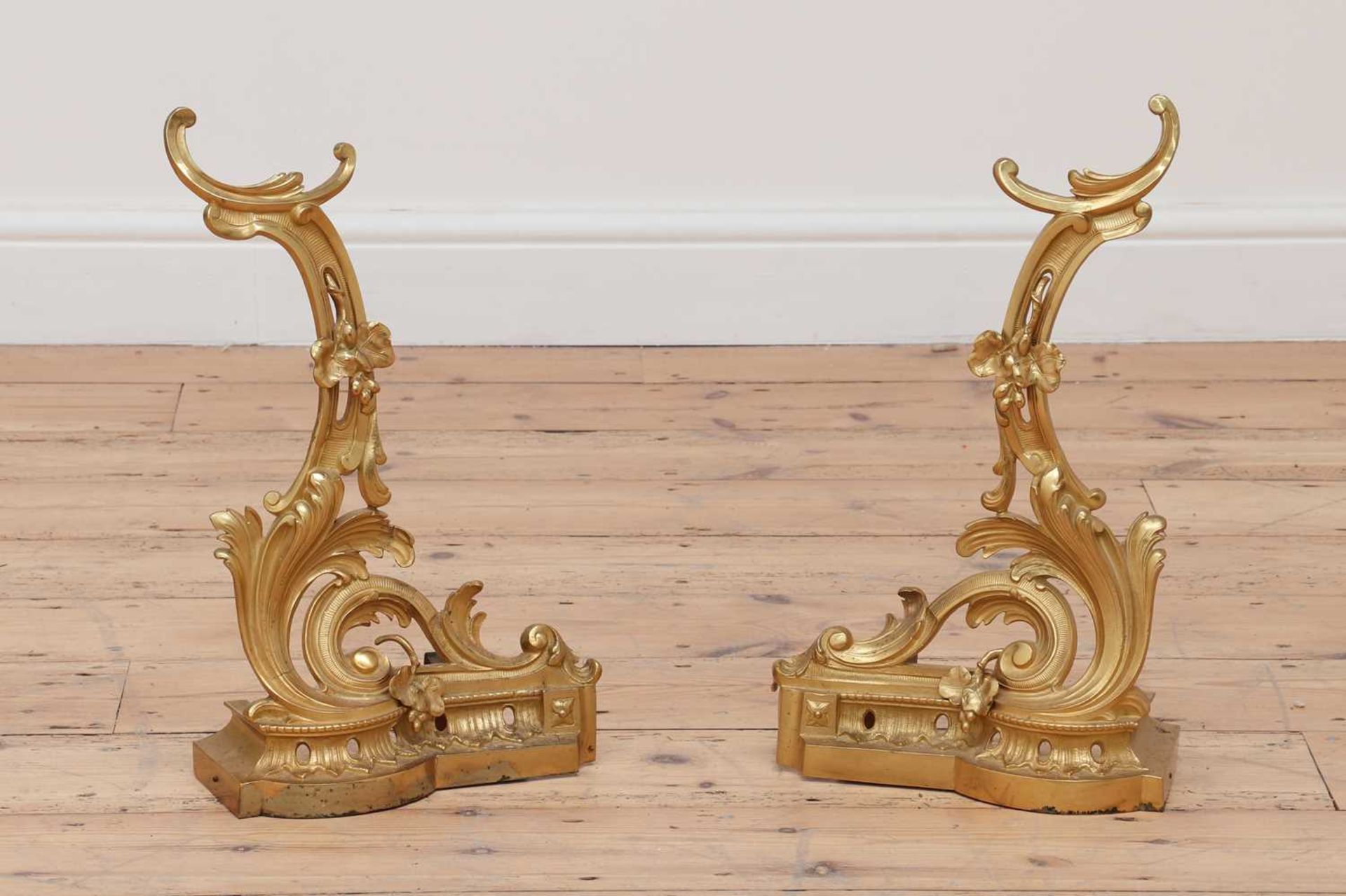 A pair of French rococo-style gilt brass chenet,