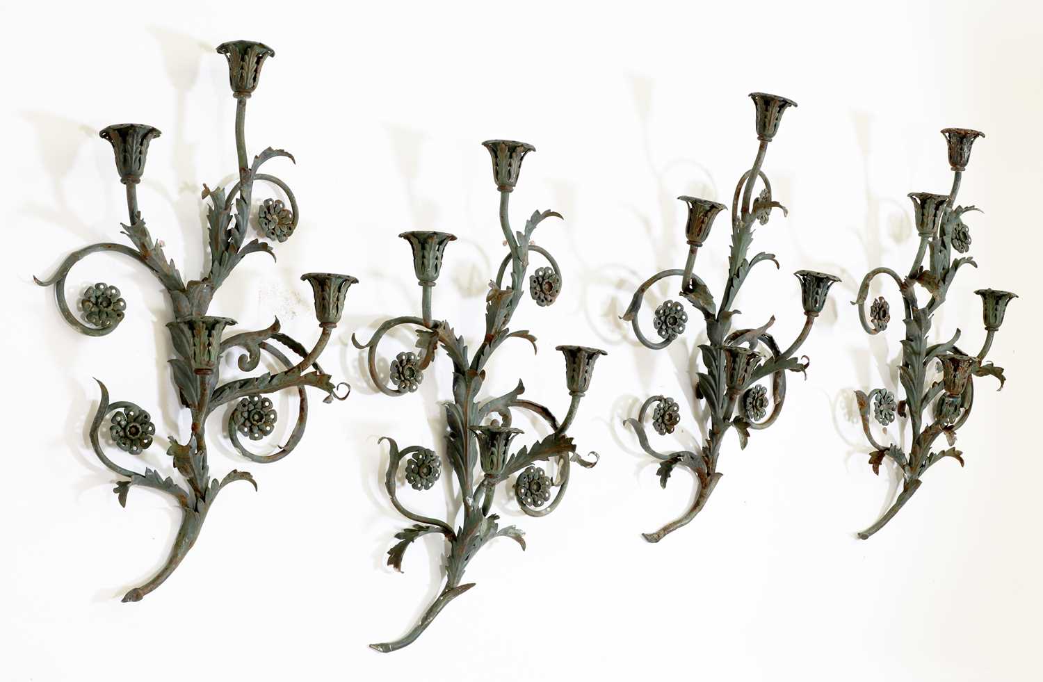 A set of four green-painted wrought iron wall lights,