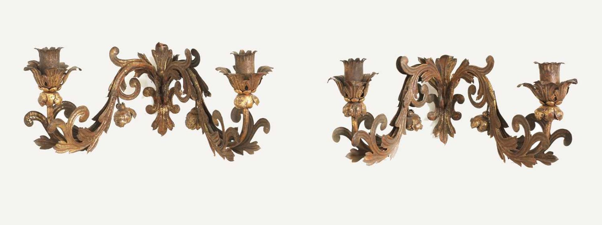 A set of four pressed and gilt-metal twin-branch wall sconces,