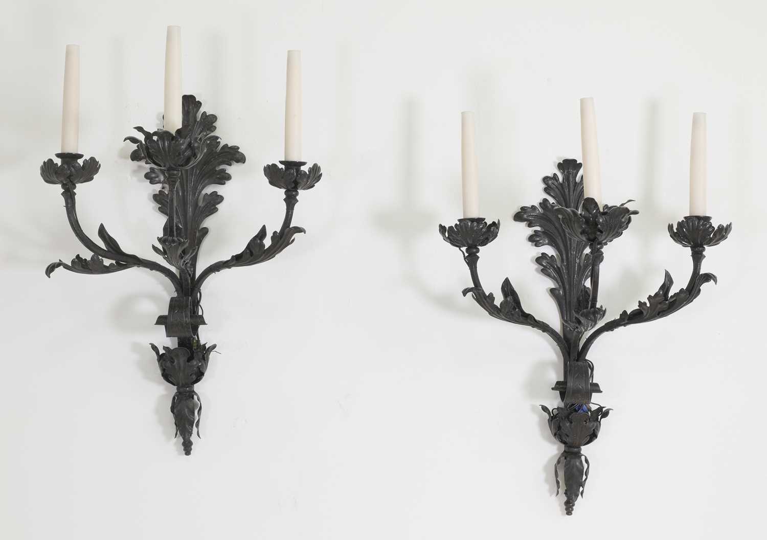 A pair of wrought iron three-branch wall lights,