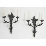 A pair of wrought iron three-branch wall lights,