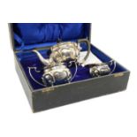 A cased three piece Edwardian silver tea service,