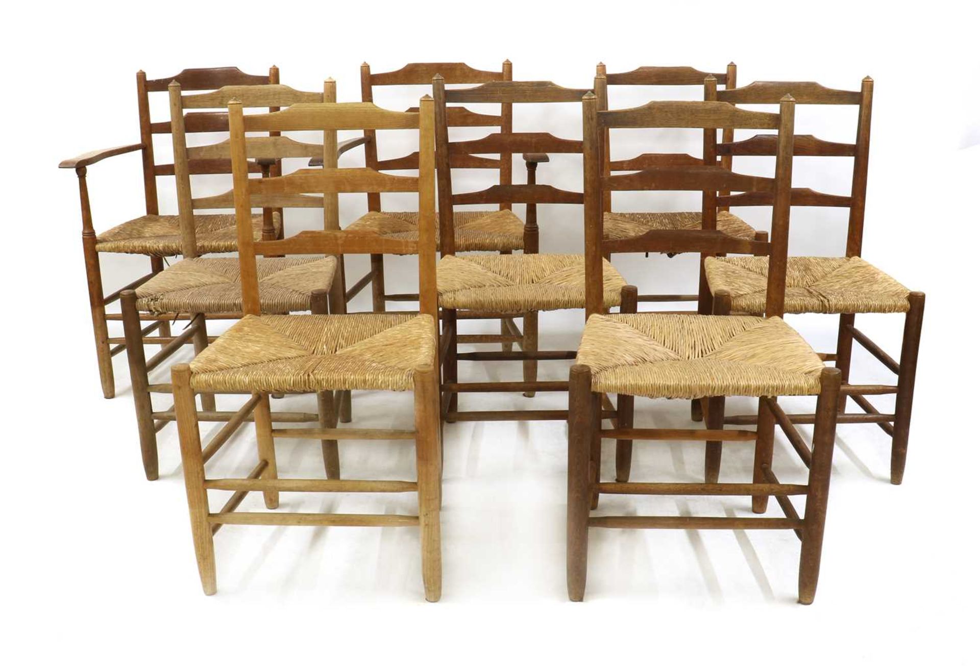 A matched set of eight Arts and Crafts 'Gimson' oak and ash ladder back chairs,