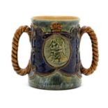 A Royal Doulton stoneware commemorative twin handled cup,