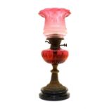 A Victorian cranberry glass oil lamp